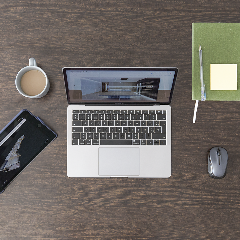 Mesa con ordenador, tablet, libreta y taza de café